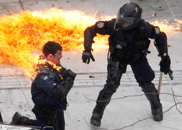 A-motorcycle-policeman-burns-as-his-colleague-tries-to-help-him-after-protesters-threw-a-petrol-bomb-in-Athens-on-February-23,-2011.