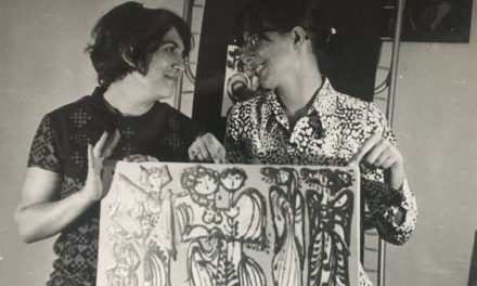 Florentina Mihai și Ligia Dumitrescu ținând o placa ceramică pictată cu o scenă din viața rurală